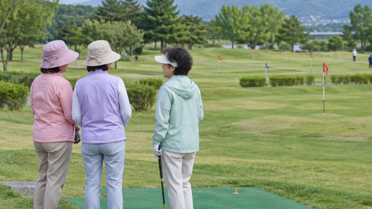 티 매트 옆에서 차례를 기다리며 이야기하는 여성 파크골퍼들 (AI 장면)